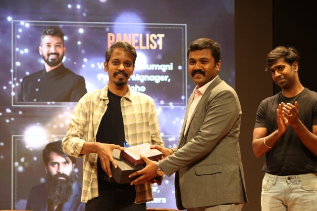 Raja T M receiving a memento on stage after the panel